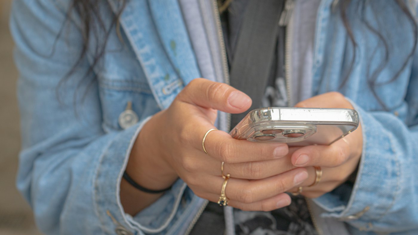 スマートフォンを両手で持って操作する手元